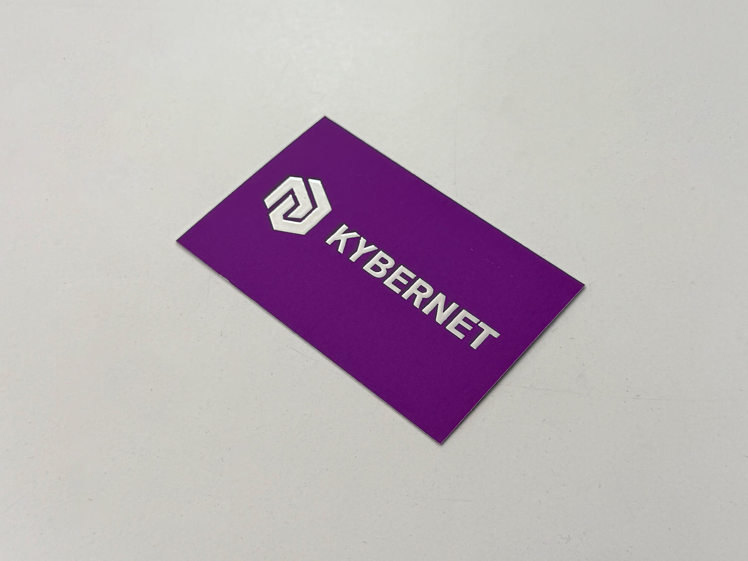 Purple business card with 'KYBERNET' logo on a gray background